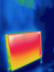 Thermal image showing a radiator that needs balancing. The cold background is show in blue and the radiator has the hottest parts in white and red gradually fading to the cooler areas in yellow